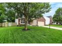 Well-kept house with a big tree, a front yard and a long driveway at 7215 Braxton Dr, Noblesville, IN 46062