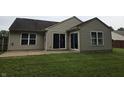 Back exterior featuring a cozy patio area with sliding glass doors and lush green lawn at 7440 Oakview Dr, Avon, IN 46123