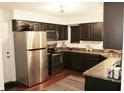 Stylish kitchen with stainless steel appliances, dark cabinetry, and a window providing plenty of natural light at 7662 Micawber Ct, Indianapolis, IN 46256
