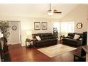 Comfortable living room featuring hardwood floors, vaulted ceiling, ceiling fan and a large window for natural light at 7662 Micawber Ct, Indianapolis, IN 46256