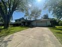 Charming exterior featuring a white brick facade, attached garage, and well-maintained front lawn at 8008 Cherington Dr, Indianapolis, IN 46227