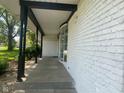 White brick house with a black beam porch, black columns, a bay window, and concrete steps at 8008 Cherington Dr, Indianapolis, IN 46227
