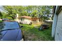 Backyard showcasing a covered patio, fence, and lush greenery at 8201 S Burlington Dr, Muncie, IN 47302