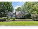 Charming brick and green two-story home with mature trees and manicured landscaping at 8315 Union Chapel Rd, Indianapolis, IN 46240
