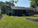 The backyard features a deck, green grass and new mulch around the perimeter of the house at 952 Delray Dr, Indianapolis, IN 46241