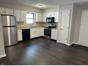 Well-lit kitchen with stainless steel appliances, white cabinets, and dark flooring at 952 Delray Dr, Indianapolis, IN 46241