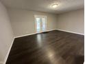 Bright living room with dark floors, neutral walls and a glass paneled door to the backyard at 952 Delray Dr, Indianapolis, IN 46241
