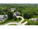 Expansive aerial view of a brick home on a large lot surrounded by lush greenery and other residences at 1008 Westcreek Dr, Columbus, IN 47201