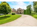 Lovely brick home with a long driveway and well-manicured lawn, exuding curb appeal and charm at 1008 Westcreek Dr, Columbus, IN 47201