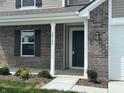 Inviting entryway showcasing brick facade, dark front door, and manicured landscaping at 10144 Camp Creek Way, Indianapolis, IN 46229
