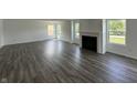 Bright living room featuring luxury vinyl flooring, a cozy fireplace, and abundant natural light from several windows at 10144 Camp Creek Way, Indianapolis, IN 46229