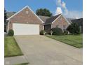 Picture of the exterior showcasing the home's brick facade, well maintained lawn, and two-car garage at 10477 Silver Ridge Cir, Fishers, IN 46038