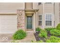 Inviting front entrance with green door, brick accents and manicured landscaping at 1139 Fernwood Way, Plainfield, IN 46168