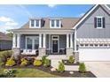 Beautiful home featuring gray siding, white trim, a welcoming front porch with swing, and well-maintained landscaping at 12078 Black Mill Pass, Fishers, IN 46040