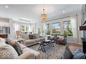 Bright living room featuring hardwood floors, large windows, stylish furniture, and an elegant chandelier at 12078 Black Mill Pass, Fishers, IN 46040