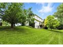Spacious backyard showcasing a well-maintained lawn and mature trees, providing a private and serene outdoor space at 13020 Lombard Ct, Fishers, IN 46038