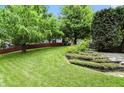 Expansive backyard featuring lush green lawn, mature trees, and tiered landscaping, ideal for outdoor living at 13020 Lombard Ct, Fishers, IN 46038
