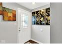 Entryway with a decorative glass front door, gray walls, and artwork, leading into the home at 1305 Gumwood Dr, Indianapolis, IN 46234