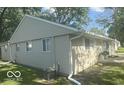 Home featuring vinyl siding, white-framed windows, and well-maintained landscaping at 1306 Woodbine Dr, Anderson, IN 46011
