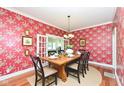Formal dining room with stylish wallpaper, hardwood floors, and French doors, perfect for hosting dinner parties at 1325 Fordice Rd, Lebanon, IN 46052
