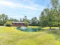 Scenic pond with a fountain, surrounded by lush greenery, and a covered bridge in the background at 1595 N 400 W, Greenfield, IN 46140
