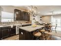 Stylish kitchen featuring dark cabinetry, granite countertops, stainless steel appliances, and an island with barstool seating at 17183 Petersfield Ln, Westfield, IN 46074