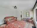 Spacious living room featuring original hardwood floors, vintage rug, and vintage couch at 1908 W Northgate St, Indianapolis, IN 46228