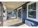 Inviting covered front porch with stone pillars, a stylish front door, and natural wood ceiling at 2954 N Washington Blvd, Indianapolis, IN 46205