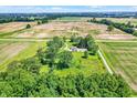 This aerial shot captures the property's location amidst vast fields and mature trees, ensuring privacy at 3001 W 226Th St, Sheridan, IN 46069