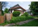 Charming home featuring a stucco exterior, quaint landscaping, and a picket fence at 320 N Colorado Ave, Indianapolis, IN 46201