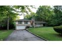 Charming two-story home with stone accents, green shutters, and an attached garage situated on a lush green lawn at 3253 W 34Th St, Indianapolis, IN 46222