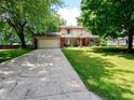 Traditional two-story home with mature trees, a spacious driveway, and manicured lawn at 336 N Windsong Ln, Greenwood, IN 46142