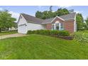 Beautifully landscaped front yard with lush green grass and manicured shrubbery at 3843 Grove Tree Ln, Indianapolis, IN 46203