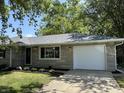 The exterior has a one car garage, stone facade, manicured landscaping, and attractive front door at 3906 N Lanewood Dr, Muncie, IN 47304