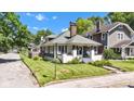 View of charming home with a manicured lawn, established trees, and a classic chimney at 4721 Carrollton Ave, Indianapolis, IN 46205