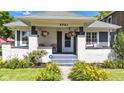 Inviting front porch with seating and colorful hanging flower baskets at 4721 Carrollton Ave, Indianapolis, IN 46205