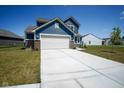 A charming two-story home featuring blue siding, a two-car garage, and a well-maintained lawn at 507 Redvine Dr, Sheridan, IN 46069