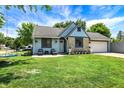 Charming home with stone accents, blue siding, inviting front yard, and a swing set at 5821 Pemberly Dr, Indianapolis, IN 46221