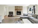 Comfortable living room with a stone fireplace, wood floors, and a gray sectional couch at 5821 Pemberly Dr, Indianapolis, IN 46221
