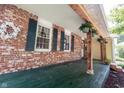Charming porch with exposed beams, hanging plants, and brick siding at 6028 Thornwood Ct, Indianapolis, IN 46250
