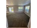 Spacious living room featuring plush carpeting, neutral walls, and sliding glass doors to enhance natural light and space at 6504 Potomac Square Ln, Indianapolis, IN 46268