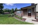 Exterior shot of a well-maintained brick home, highlighted by a manicured lawn and colorful flowerbeds at 6602 S 400 W, Columbus, IN 47201