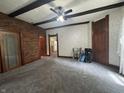 Spacious living room featuring exposed beams, a brick accent wall, and views to an adjacent space at 6895 N County Road 625 E, Brownsburg, IN 46112