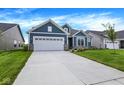 Attractive blue home featuring a two-car garage, stone details, and a well-maintained lawn at 7195 Rose Hill Ave, Brownsburg, IN 46112