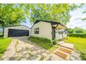 Exterior view of a home with a detached garage and walkway to the front door at 8210 Patton Dr, Lawrence, IN 46226