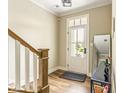 Bright entryway with hardwood floors, a staircase, and a glass-paneled front door at 830 Freeland Way, Carmel, IN 46032