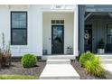 The front entrance features a black door, fresh landscaping, and a concrete walkway at 830 Freeland Way, Carmel, IN 46032