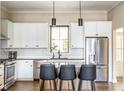 Stylish kitchen with white cabinets, stainless steel appliances, and an island with barstool seating at 830 Freeland Way, Carmel, IN 46032