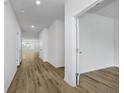 Bright hallway with wood-look flooring, white trim, and doors leading to various rooms at 8344 Leander Ave, Zionsville, IN 46077