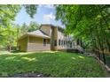 Lush green lawn leads up to a yellow home with a spacious back deck, partially enclosed by wooden fencing at 9722 N Gasburg Rd, Mooresville, IN 46158